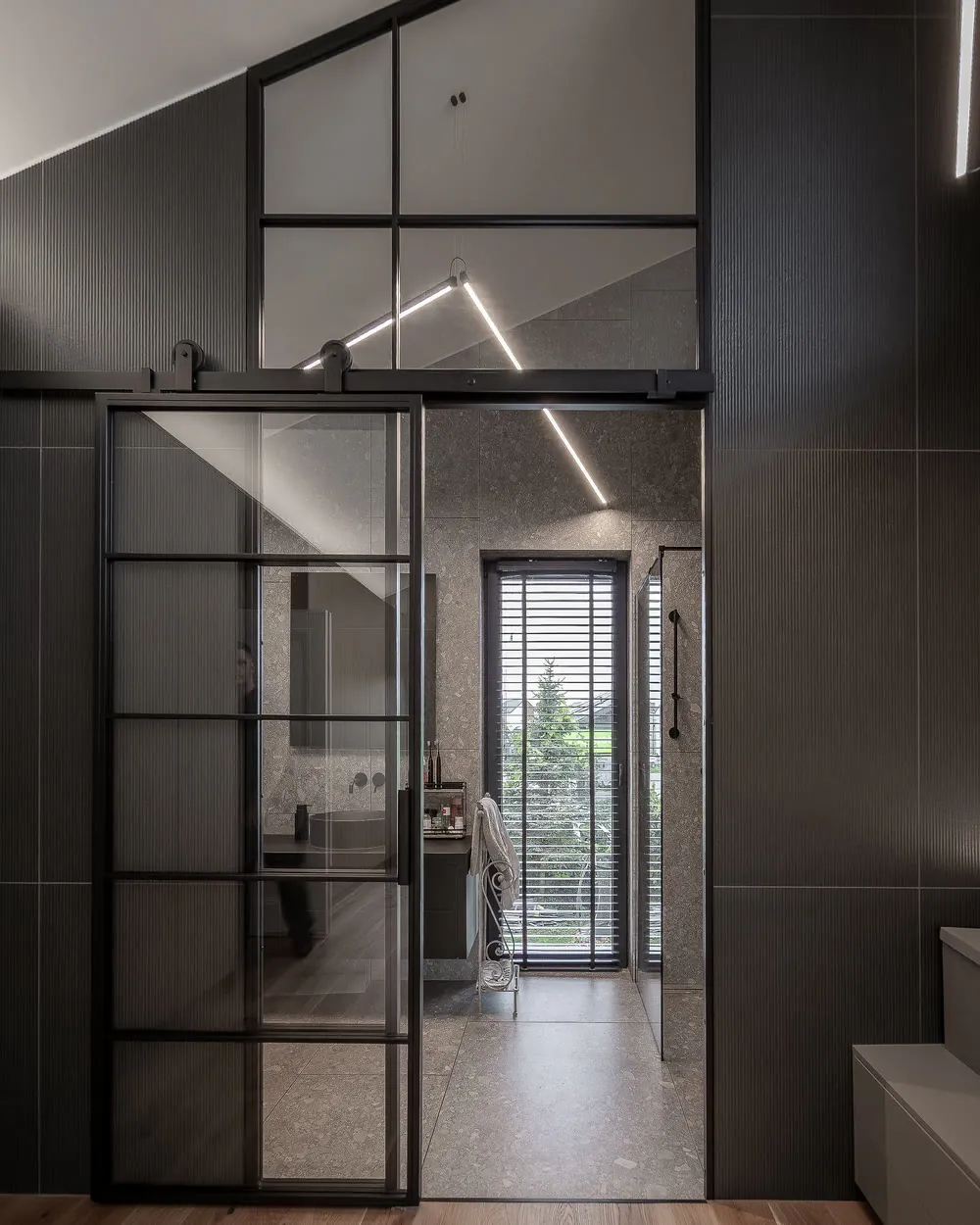 The Barn Bathroom, Richmond: steel sliding door in a dark interior